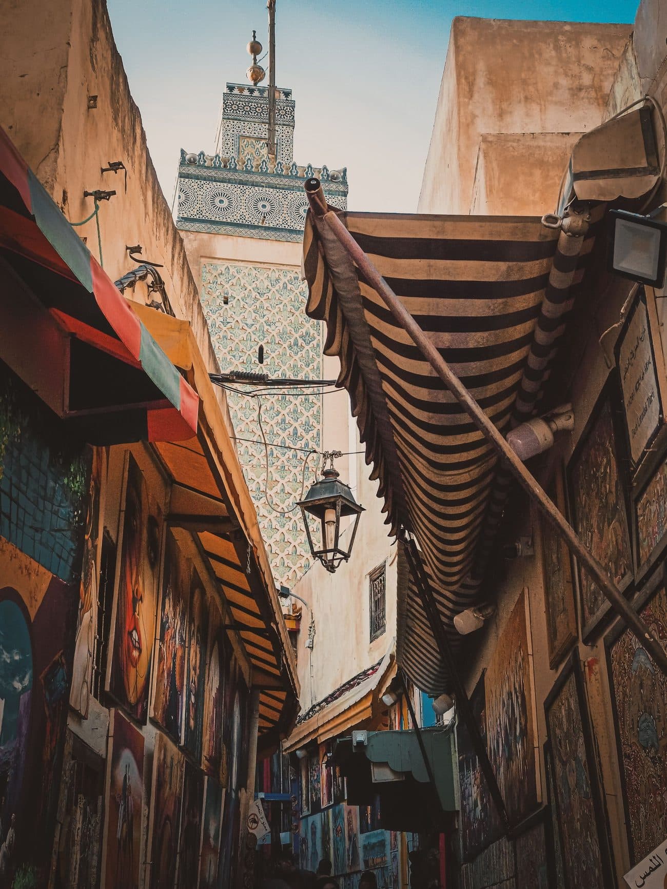 Covered alley in the Fez souk leading towards a minaret