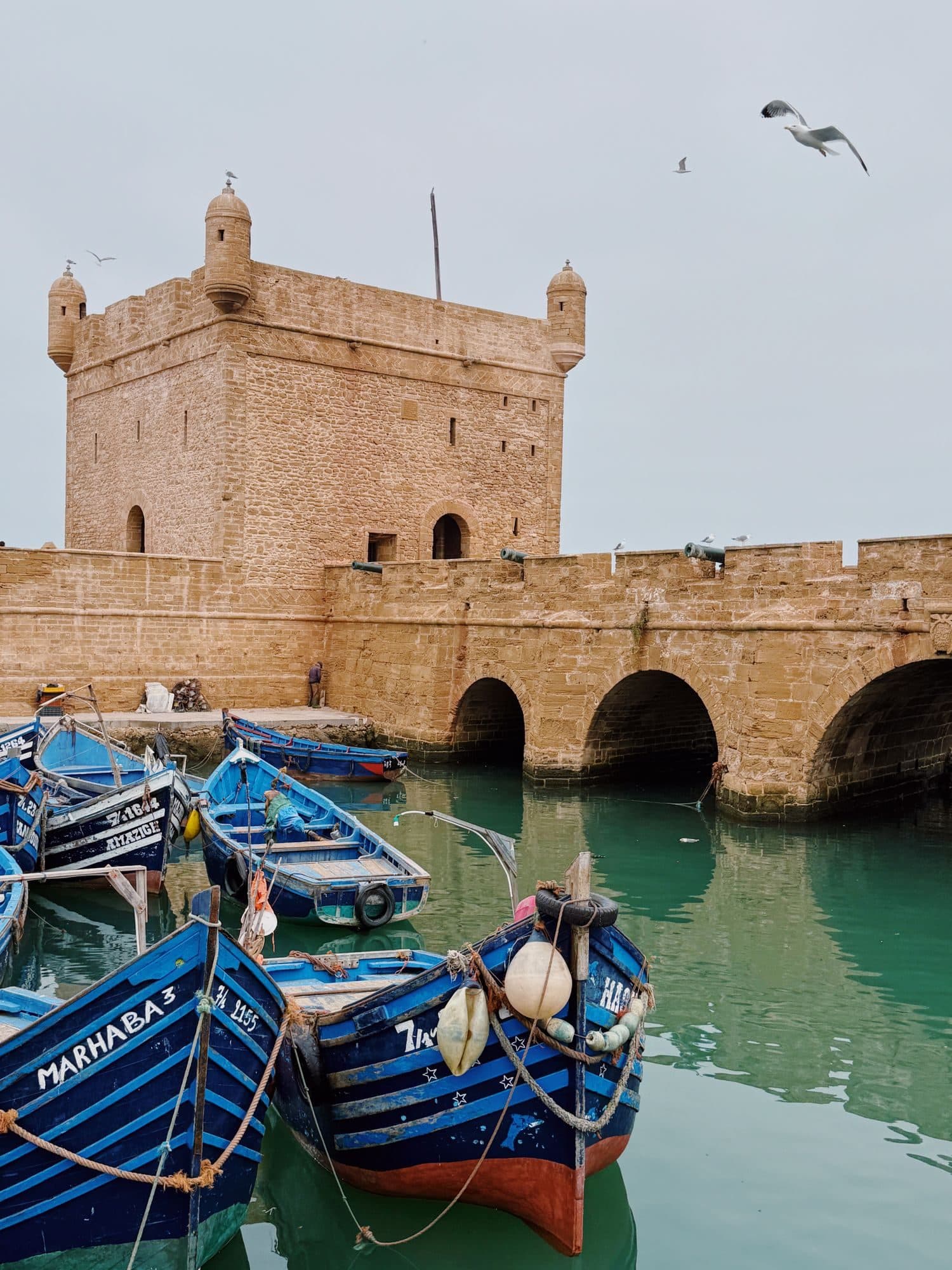 The Essaouira fortress and blue fishing boats in the harbour