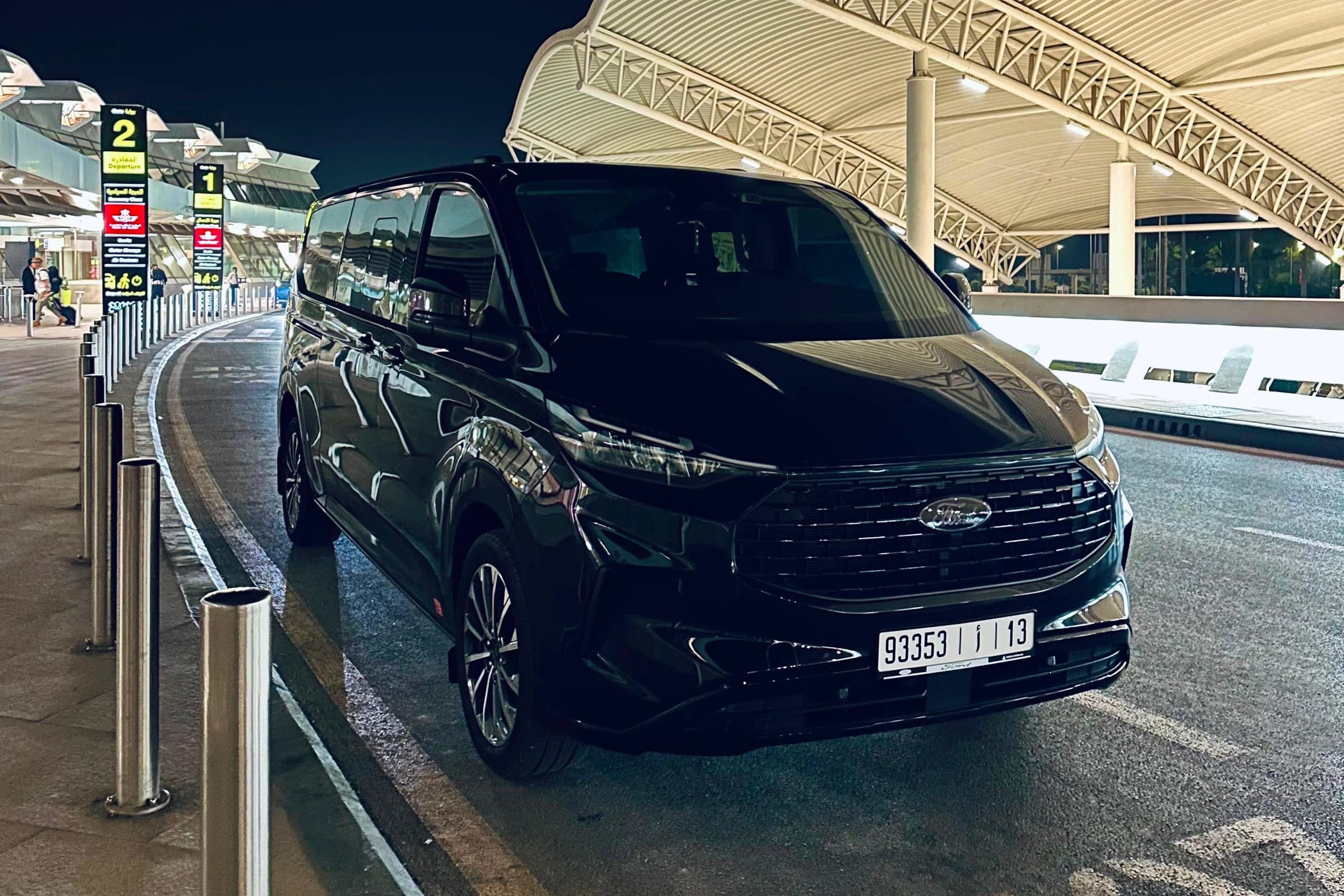 Black Ford Tourneo from Morocco Travel Transfr parked at night outside the departures terminal of a Moroccan airport